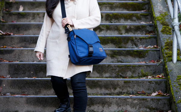 A person descending a set of stairs while carrying the Maker's Bag.